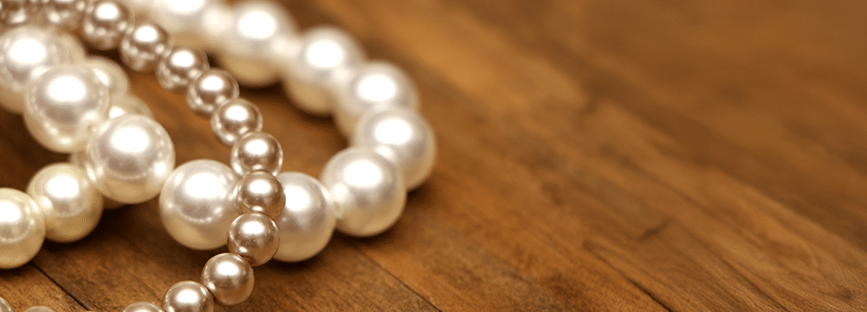 strings of pearls on a wooden surface