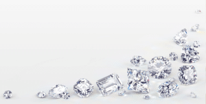 several diamonds in a variety of cuts and shapes scattered on a white background